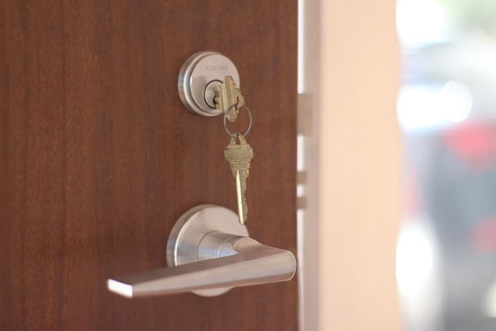 Cerrajería llaves Barranquilla puerta de madera con llaves colgando