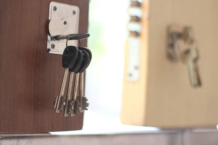Cerrajería llaves Barranquilla llaves colgadas en puerta de madera
